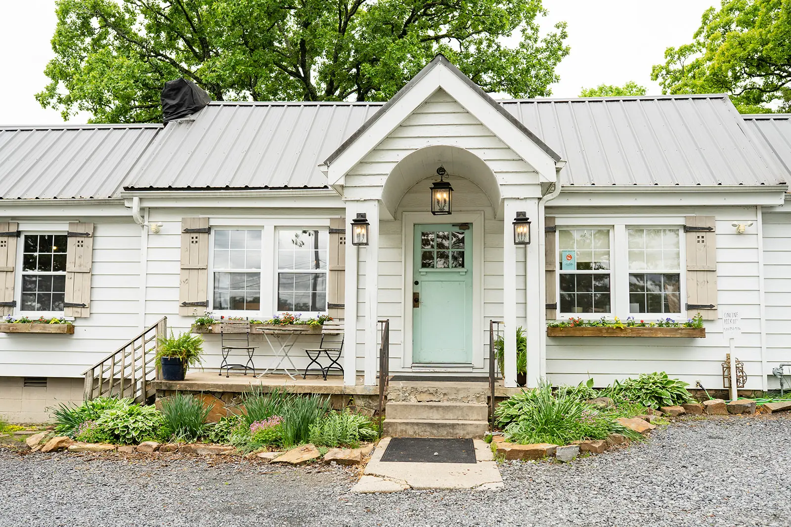 The Humble Crumb bakery, a white cottage with a mint front door and arched portico